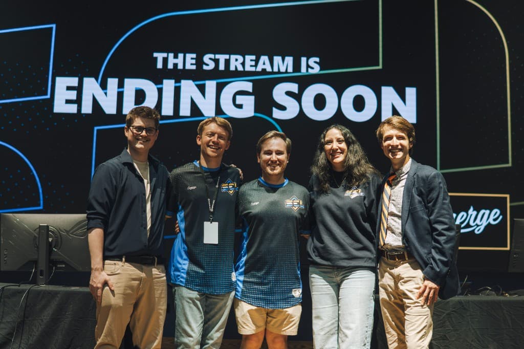 Gaming Oasis staff on stage at an SEL broadcast with team members in league apparel